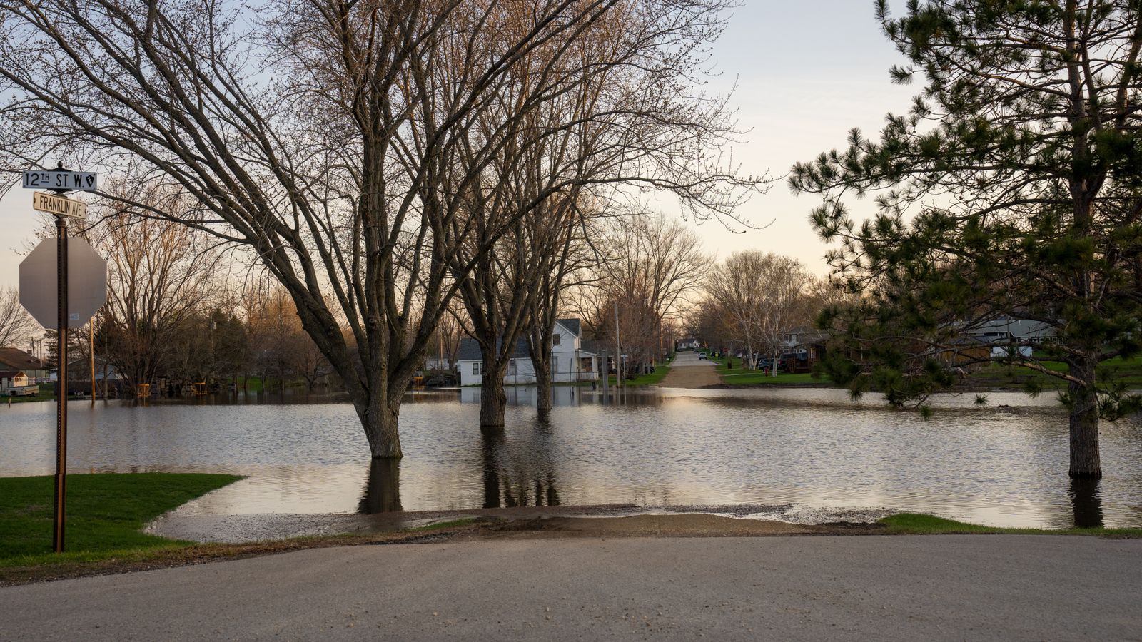 An American residential intersection submerged by floodwater at golden hour